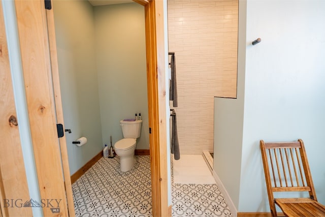 full bathroom featuring a shower stall, toilet, and baseboards