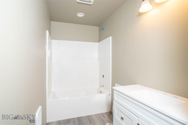 bathroom with washtub / shower combination, visible vents, vanity, and wood finished floors