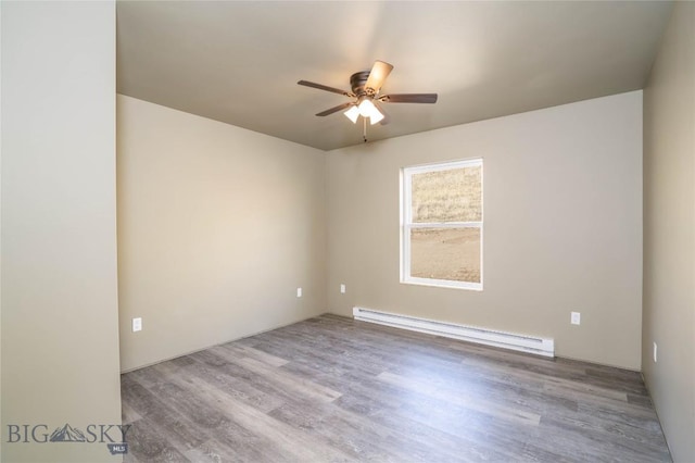 empty room featuring a ceiling fan, a baseboard heating unit, and wood finished floors