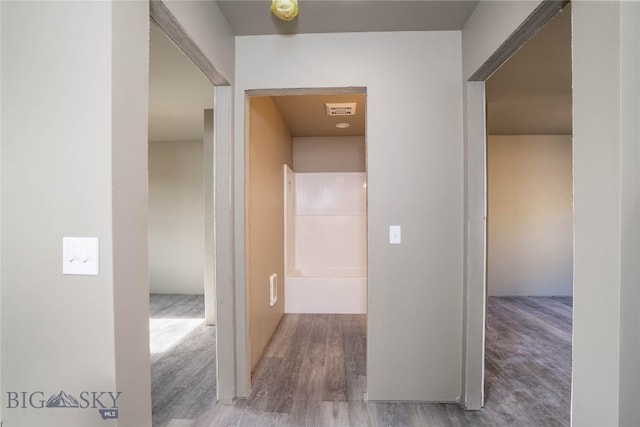 corridor with visible vents and wood finished floors