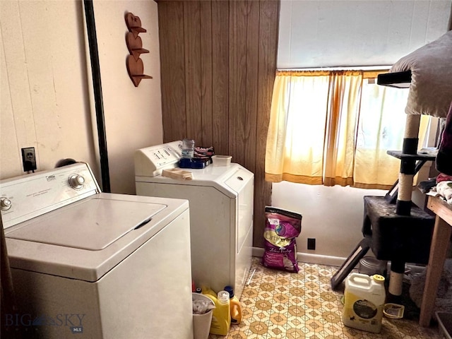 laundry area featuring laundry area, wood walls, independent washer and dryer, and tile patterned floors