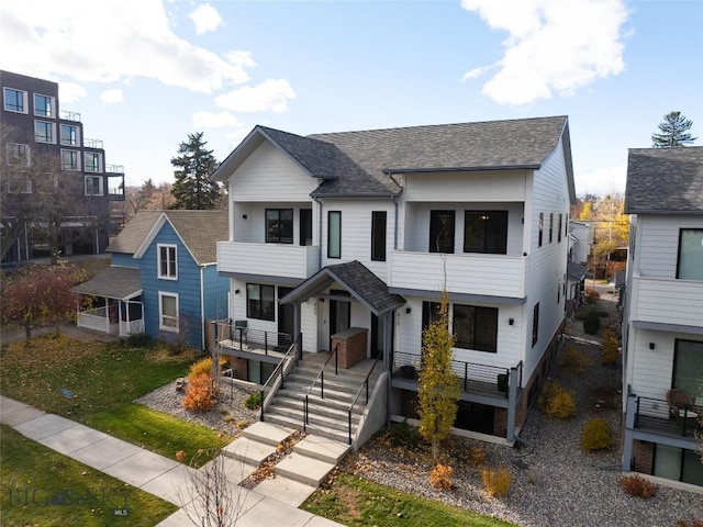 view of front of home featuring a balcony and roof with shingles