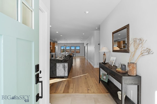 foyer entrance with light wood-style floors and recessed lighting