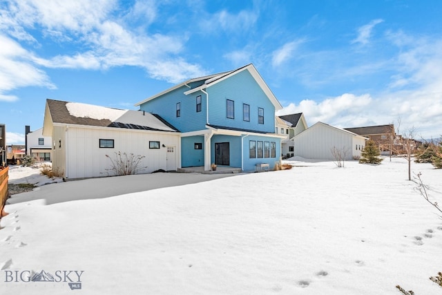 view of snow covered back of property