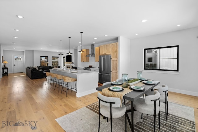 dining room featuring light wood-style flooring, baseboards, and recessed lighting