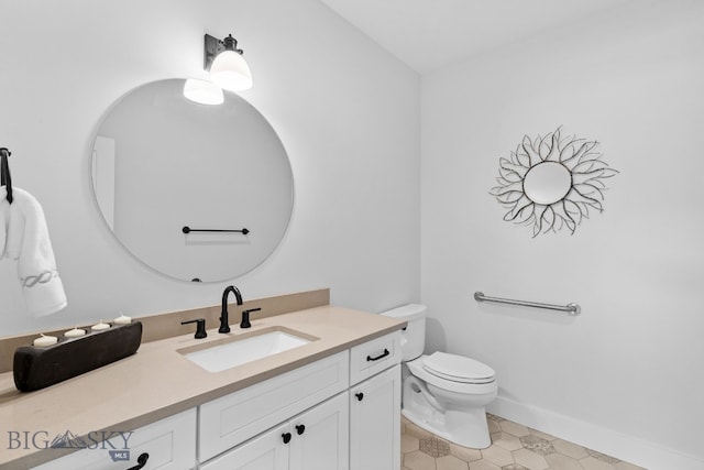 bathroom featuring vanity, toilet, and baseboards