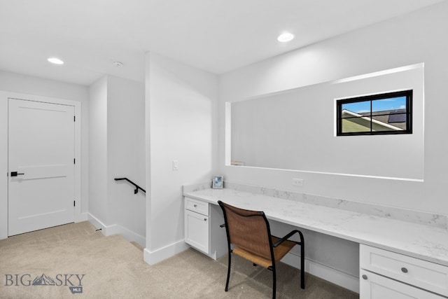 office featuring recessed lighting, baseboards, light colored carpet, and built in study area