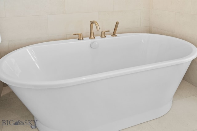 bathroom with a soaking tub, tile walls, and tile patterned floors