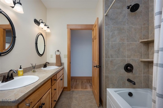 bathroom featuring double vanity, shower / tub combo, tile patterned flooring, and a sink