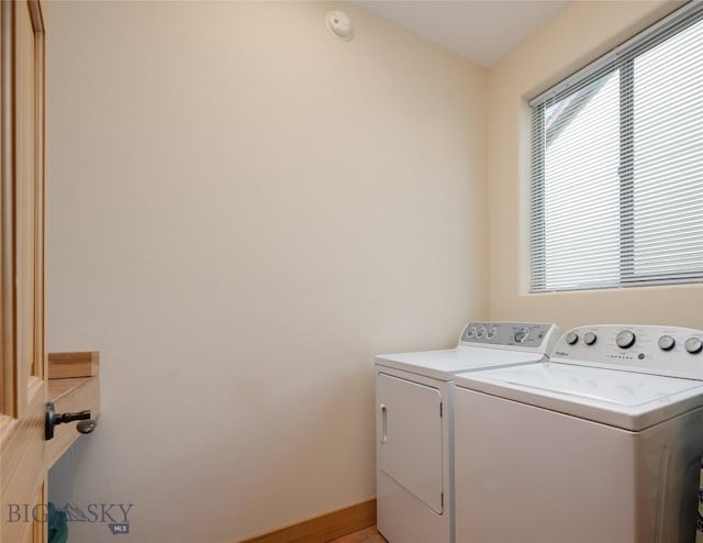 laundry room with a wealth of natural light, laundry area, baseboards, and washing machine and clothes dryer