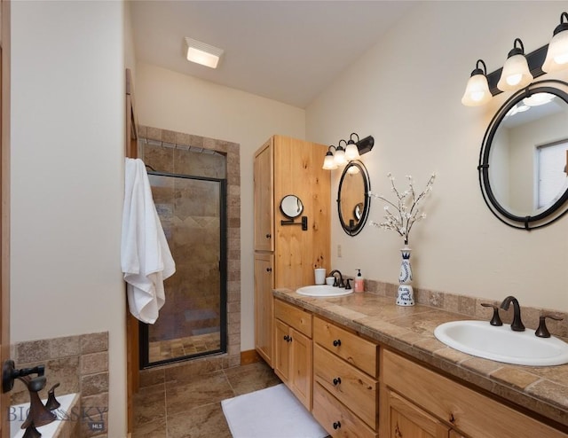 full bath featuring a sink, a shower stall, and double vanity