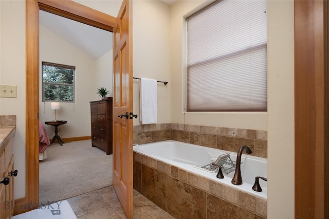 bathroom with lofted ceiling and a bath