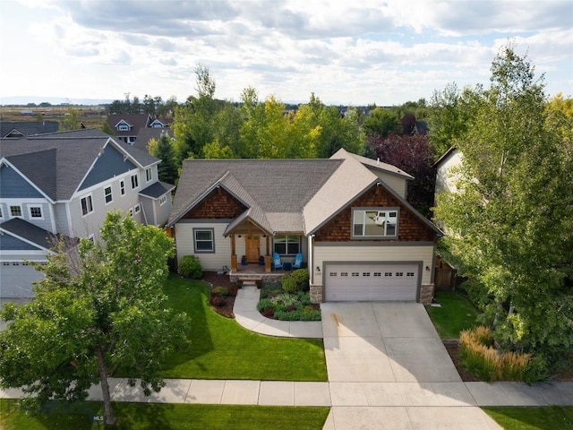 craftsman house featuring driveway, stone siding, and a front yard