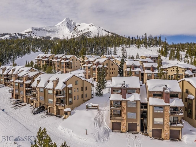 snowy aerial view featuring a residential view and a mountain view