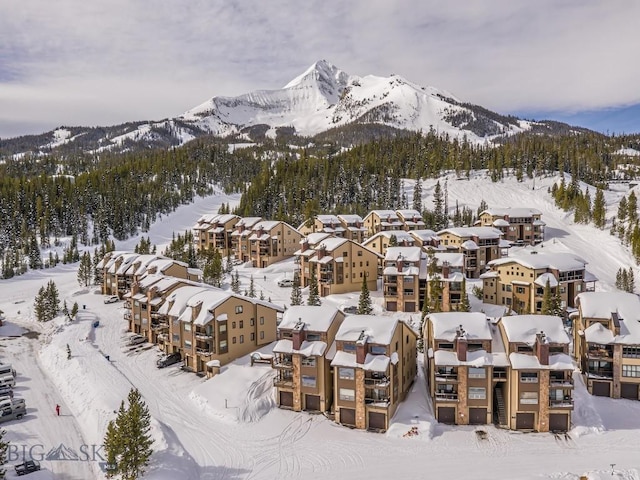 snowy aerial view featuring a residential view and a mountain view