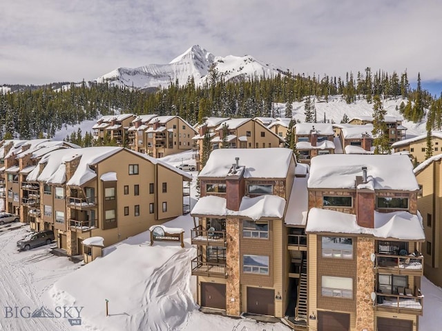 snowy aerial view featuring a residential view and a mountain view