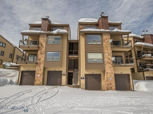 snow covered building featuring a garage