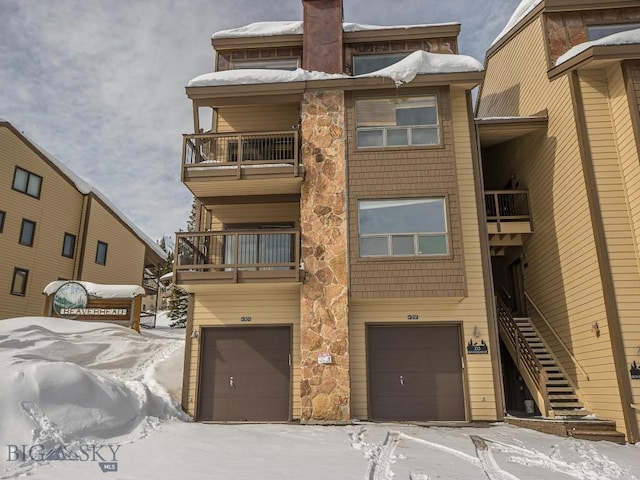 view of front of home with an attached garage and a balcony