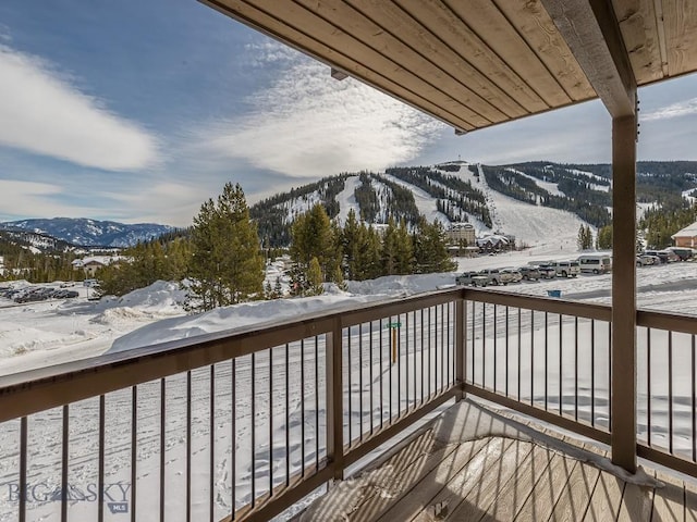 snow covered back of property featuring a mountain view