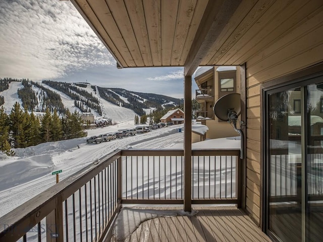 snow covered back of property featuring a mountain view