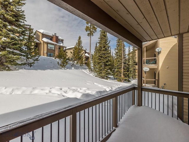 view of snow covered back of property