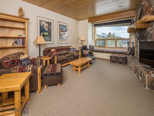 living area with carpet floors, wood ceiling, and a stone fireplace