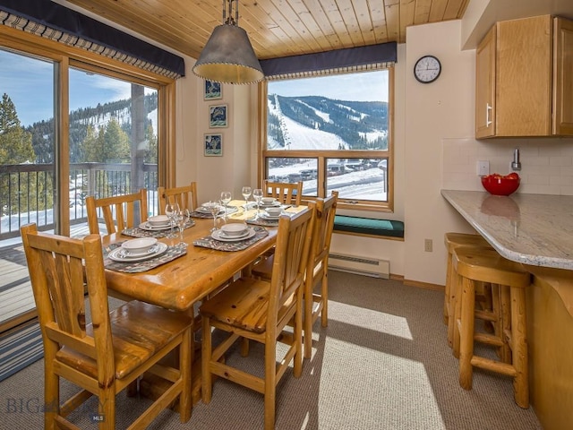 dining area featuring light carpet, wood ceiling, a baseboard heating unit, and baseboards