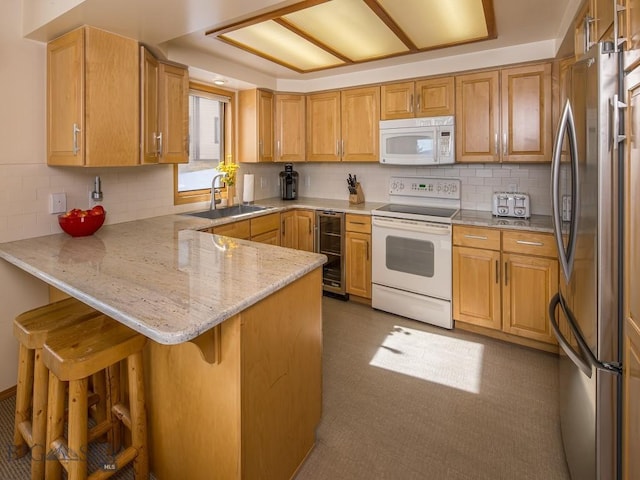 kitchen with tasteful backsplash, a sink, beverage cooler, white appliances, and a peninsula