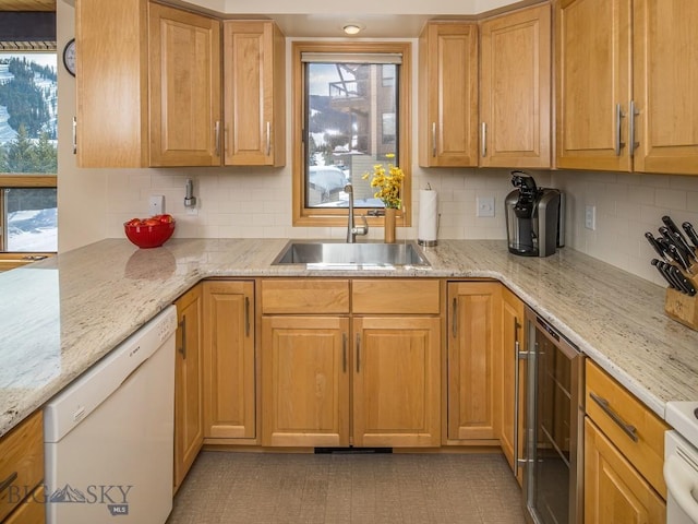 kitchen featuring beverage cooler, dishwasher, light stone counters, backsplash, and a sink