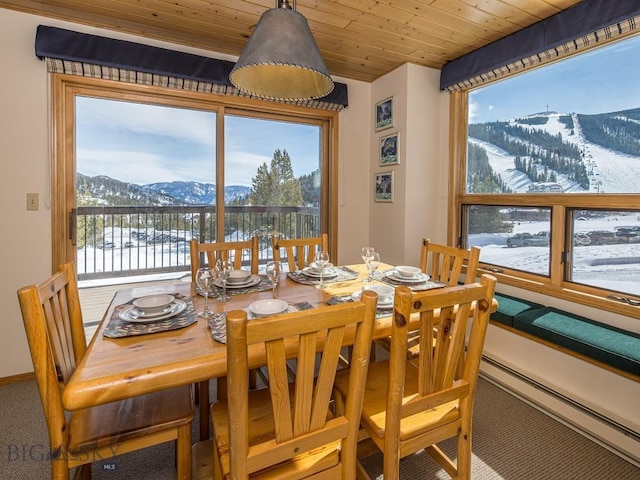 dining space featuring wood ceiling, carpet, and a mountain view