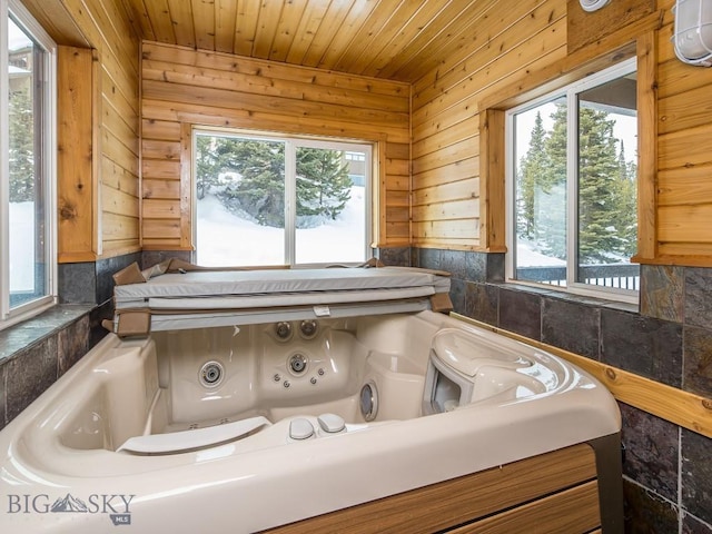 interior space with wooden ceiling and a jetted tub