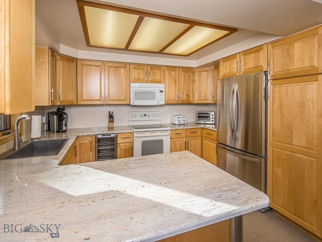 kitchen with white appliances, wine cooler, a sink, and light stone countertops