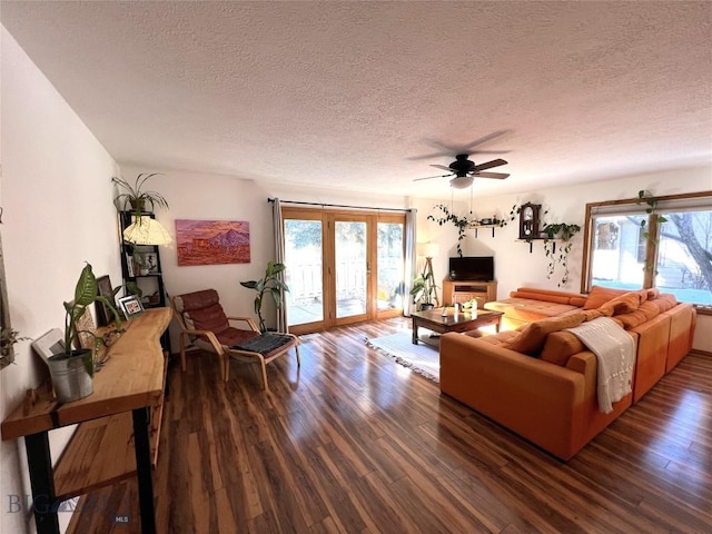 living room featuring ceiling fan, a textured ceiling, and wood finished floors