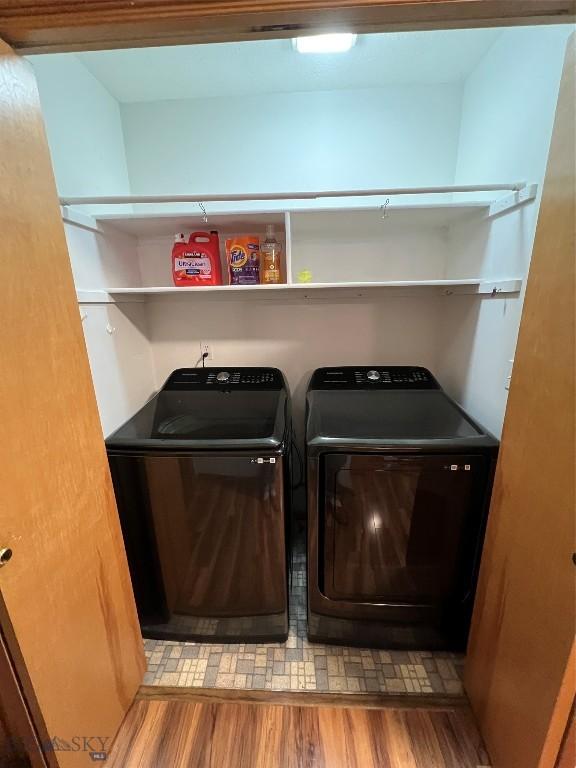 clothes washing area with light wood-style floors, laundry area, and separate washer and dryer