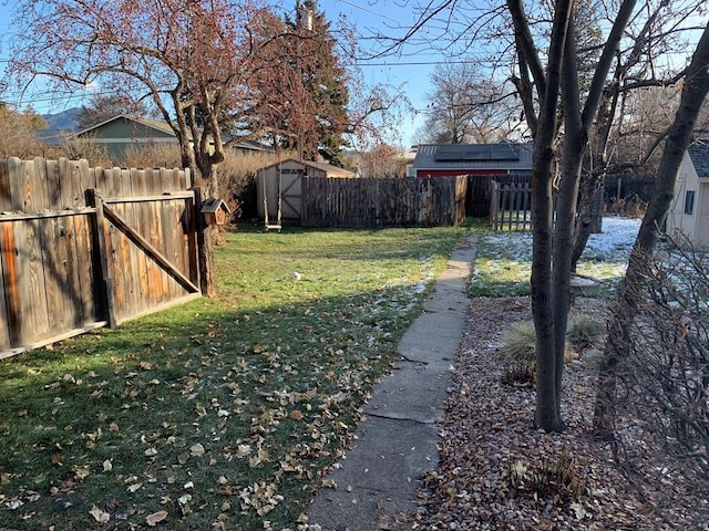 view of yard with fence private yard, a storage shed, and an outdoor structure