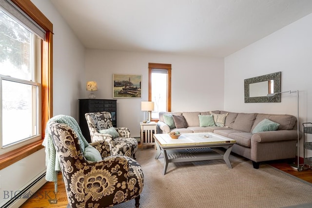 living room with a baseboard heating unit and wood finished floors