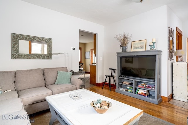 living area featuring baseboards and wood finished floors