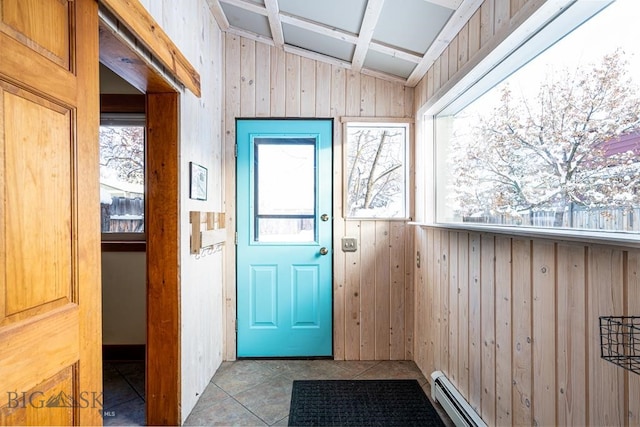 entryway featuring wood walls, baseboard heating, vaulted ceiling, and tile patterned floors