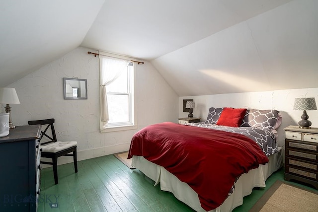 bedroom with baseboards, vaulted ceiling, and hardwood / wood-style floors