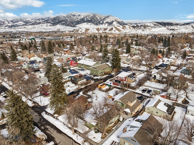 snowy aerial view with a mountain view and a residential view