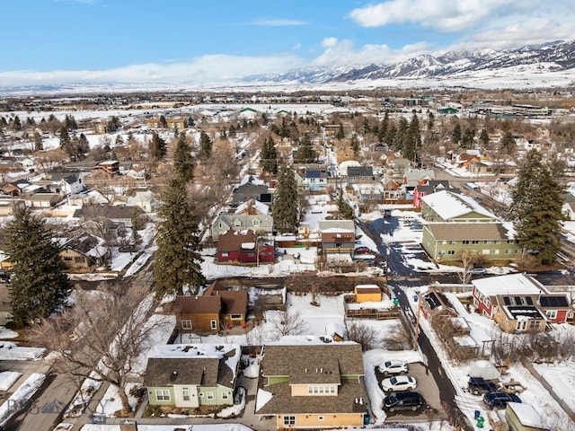 snowy aerial view with a mountain view and a residential view