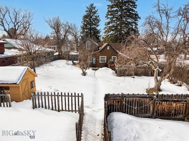 yard layered in snow featuring fence private yard and an outdoor structure