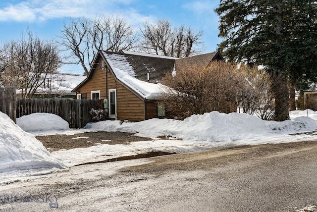 snow covered property with fence