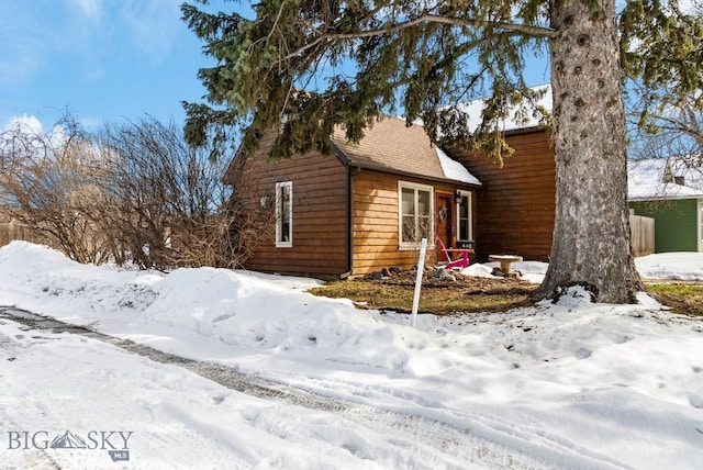 snow covered property with a garage