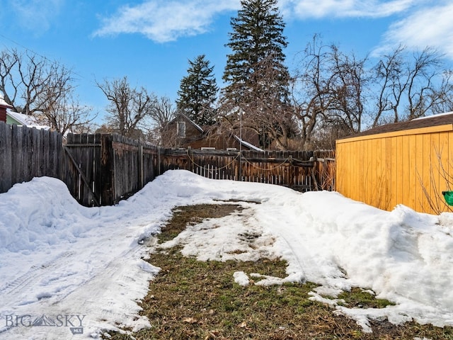 yard covered in snow with a fenced backyard