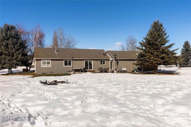 view of snow covered back of property