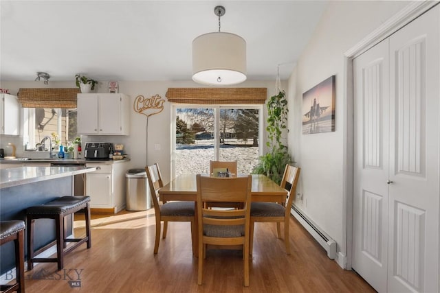 dining area featuring light wood-style floors and baseboard heating