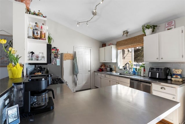 kitchen with decorative backsplash, dishwasher, vaulted ceiling, white cabinetry, and a sink