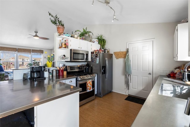 kitchen with lofted ceiling, white cabinetry, appliances with stainless steel finishes, stainless steel counters, and open shelves