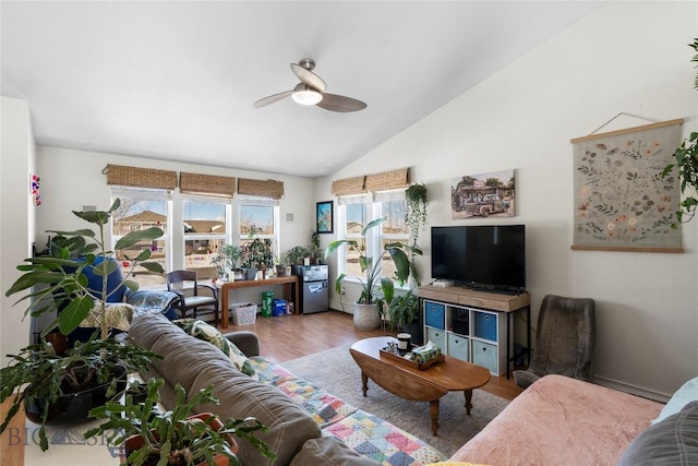 living area with vaulted ceiling, wood finished floors, and a ceiling fan